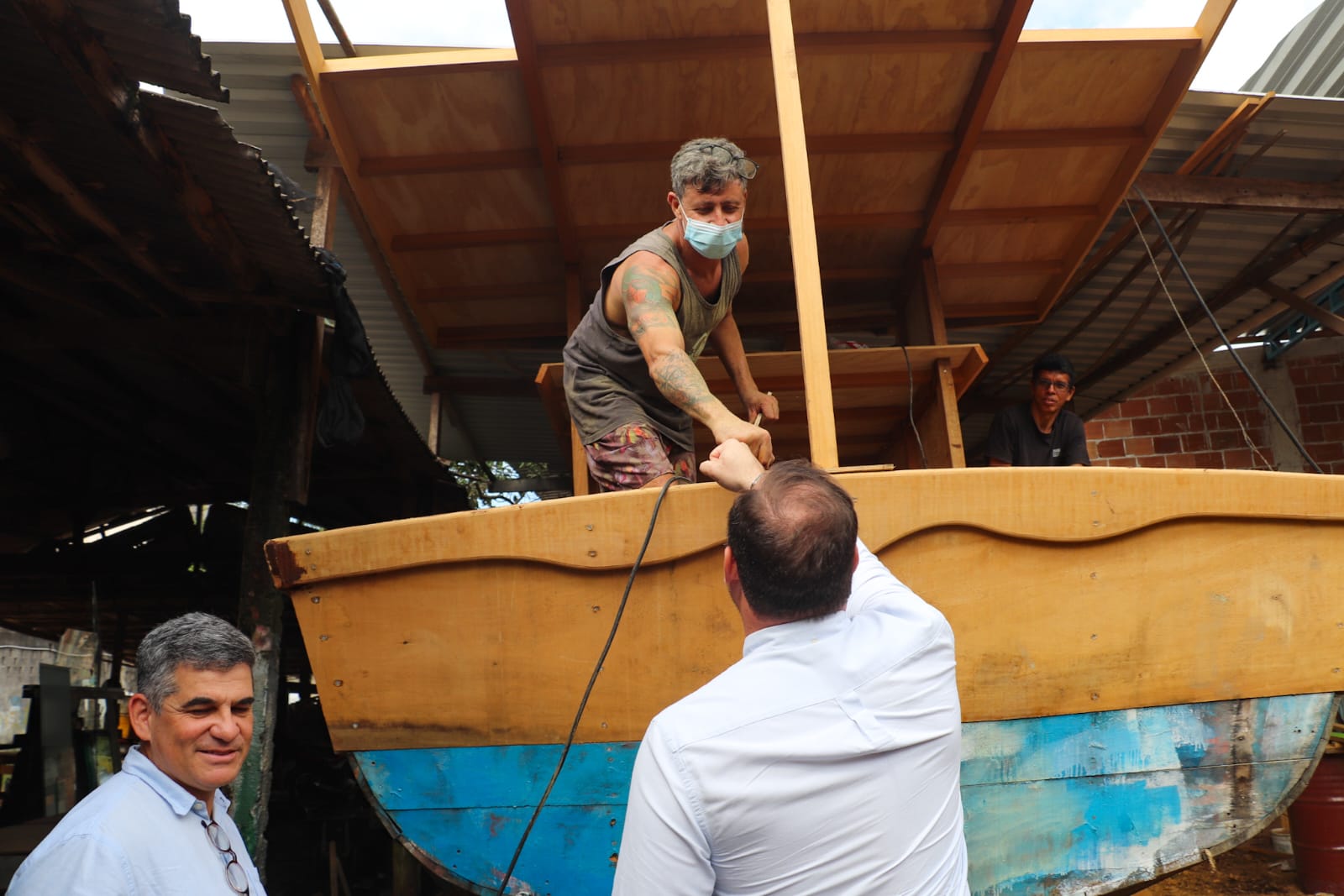 Dr. Victor Linhalis cumprimenta pescadores em estaleiro de barcos artesanais